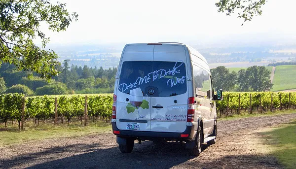 Drive Me To Drink Wine tour van overlooking vineyards in Oregon&rsquo;s Willamette Valley.