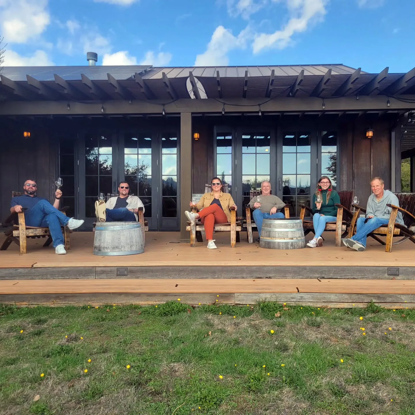 Small group relaxing with wine on a covered patio at a McMinnville winery in Oregon’s Willamette Valley